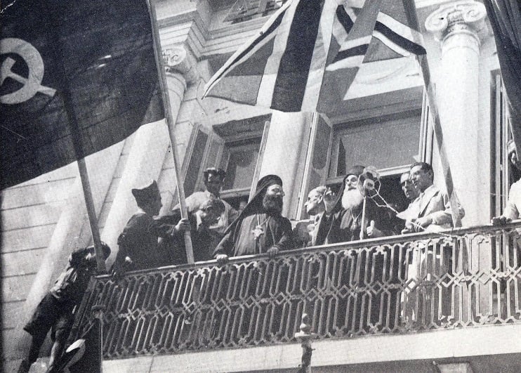 Ο μητροπολίτης Μηθύμνης Διονύσιος, Πρόεδρος της Νομαρχιακής Επιτροπής του ΕΑΜ Λέσβου, μιλά στο πλήθος, από τον εξώστη του δημαρχείου στην προκυμαία της Μυτιλήνης, τις πρώτες μέρες της απελευθέρωσης (12-9-1944). Μαζί του ο «Δάσκαλος» Απόστολος Αποστόλου, Γραμματέας της Ν.Ε. του ΕΑΜ, ο Βαγγέλης Γιοσμάς, Γραμματέας της Π.Ε. του ΚΚΕ, ο Σταμάτης Καββαδίας (Παύλος Οικονόμου), απεσταλμένος της Κ.Ε. του ΕΑΜ από τον Αύγουστο του 1944 για το συντονισμό της Αντίστασης στη Λέσβο - Χίο - Σάμο κ.ά. (φωτογραφία Σίμου Χουτζαίου). 