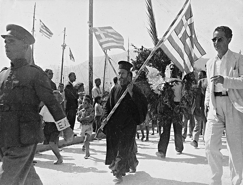 Απελευθέρωση Μυτιλήνης (10-9-1944). Ο εφεδρικός ΕΛΑΣ παρελαύνει. Αριστερά επικεφαλής ο λοχαγός Θανάσης Σκούφος, στο μέσον σημαιοφόρος ο παπά-Στρατής Αθανασιάδης από τα Αλυφαντά και δεξιά με τα άσπρα ρούχα ο Μήτσος Σγουρέλης.