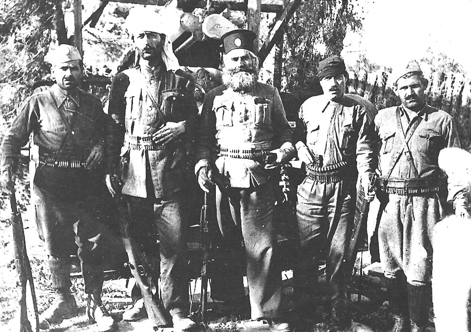 Ελασίτες φωτογραφίζονται στο στρατόπεδο του ΕΛΑΣ Λέσβου στον Καρά-Τεπέ Μυτιλήνης (1944). Δεύτερος από αριστερά ο Νίκος Σκουταριώτης ή Ολόρθος που σκοτώθηκε στον Εμφύλιο, στις 3-1-1947 στα Καμίνια Νάπης, στο μέσον ο παπά-Λευτέρης Διαμαντίδης και δεξιά ο Πέτρος Μπούρας, που επίσης σκοτώθηκε στον Εμφύλιο, στις 6-6-1949 στα Δάφια (φωτογραφία Σίμου Χουτζαίου).