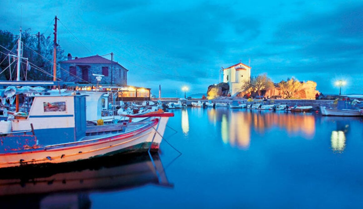 Ειδυλλιακές στιγμές στη Σκάλα Συκαμιάς, με το εκκλησάκι της Παναγιάς της Γοργόνας στην εμπασιά του λιμανιού.