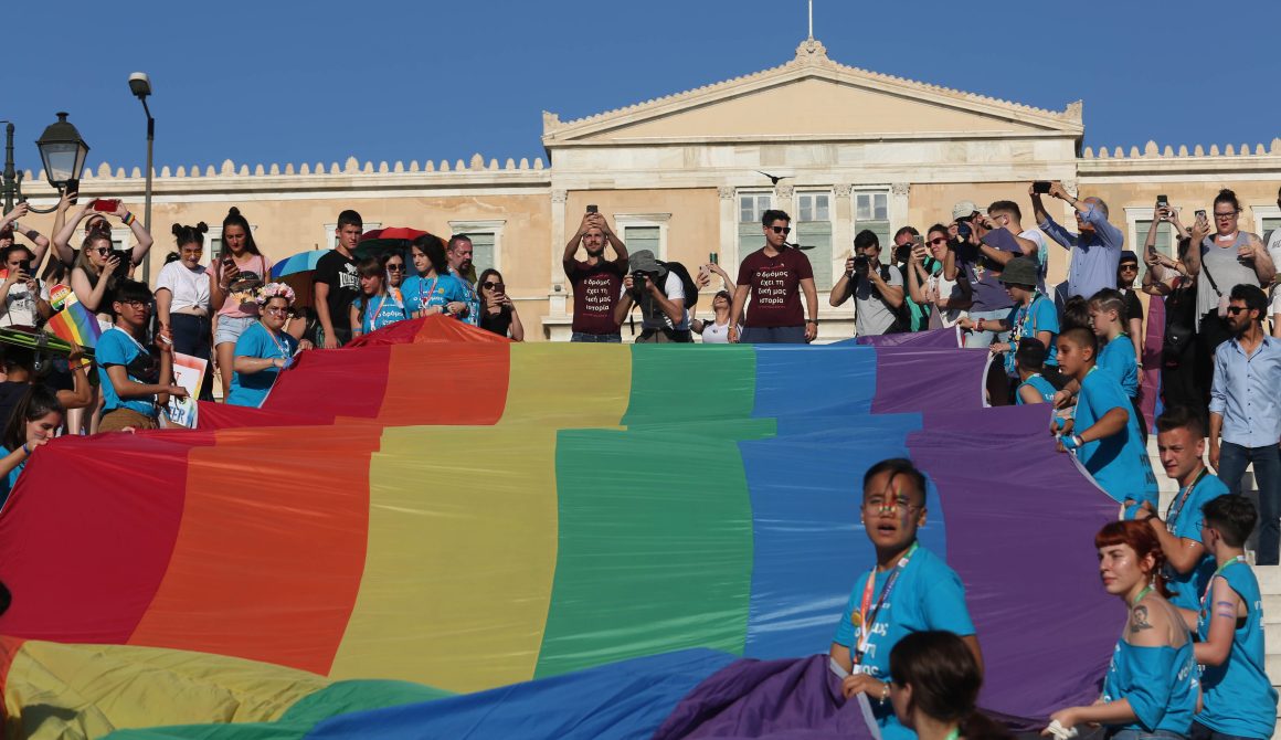  Κόσμος με ένα μεγάλο πανό στα χρώματα της ίριδας, μπροστά από το Ελληνικό Κοινοβούλιο, συμμετέχει στην ετήσια παρέλαση Athens Pride 2019 της ομοφυλόφιλης κοινότητας, η οποία μεταξύ άλλων τιμά τη μνήμη του Ζακ Κωστόπουλου, με κεντρικό σύνθημα "Ο δρόμος έχει τη δική μας ιστορία", στην πλατεία Συντάγματος, Αθήνα, Σάββατο 8 Ιουνίου 2019. 50 χρόνια συμπληρώνονται από την εξέγερση του Stonewall Inn και 15 χρόνια από το πρώτο Athens Pride Parade. ΑΠΕ-ΜΠΕ/ ΑΠΕ-ΜΠΕ/ ΑΛΕΞΑΝΔΡΟΣ ΜΠΕΛΤΕΣ
