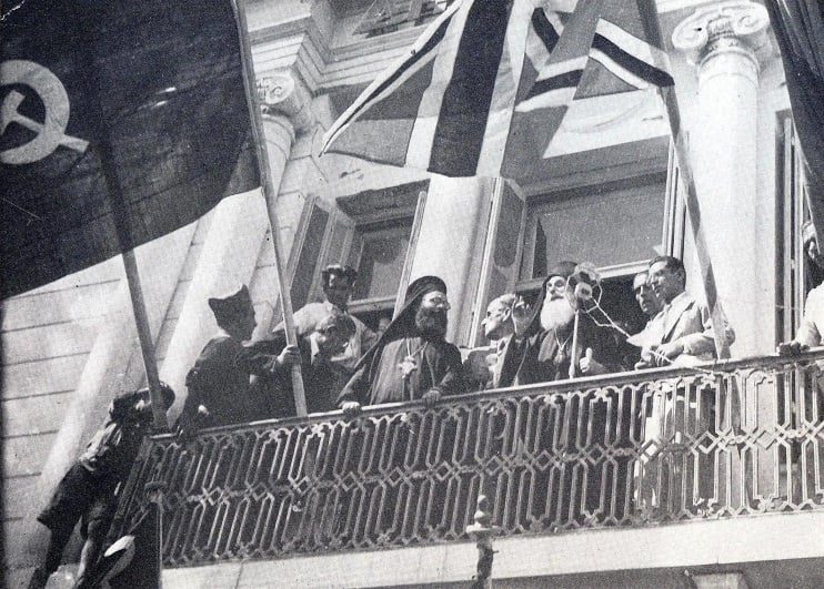 Ο μητροπολίτης Μηθύμνης Διονύσιος, Πρόεδρος της Νομαρχιακής Επιτροπής του ΕΑΜ Λέσβου, μιλά στο πλήθος, από τον εξώστη του δημαρχείου στην προκυμαία της Μυτιλήνης, τις πρώτες μέρες της απελευθέρωσης (12-9-1944). Μαζί του ο «Δάσκαλος» Απόστολος Αποστόλου, Γραμματέας της Ν.Ε. του ΕΑΜ, ο Βαγγέλης Γιοσμάς, Γραμματέας της Π.Ε. του ΚΚΕ, ο Σταμάτης Καββαδίας (Παύλος Οικονόμου), απεσταλμένος της Κ.Ε. του ΕΑΜ από τον Αύγουστο του 1944 για το συντονισμό της Αντίστασης στη Λέσβο - Χίο - Σάμο κ.ά. (φωτογραφία Σίμου Χουτζαίου).